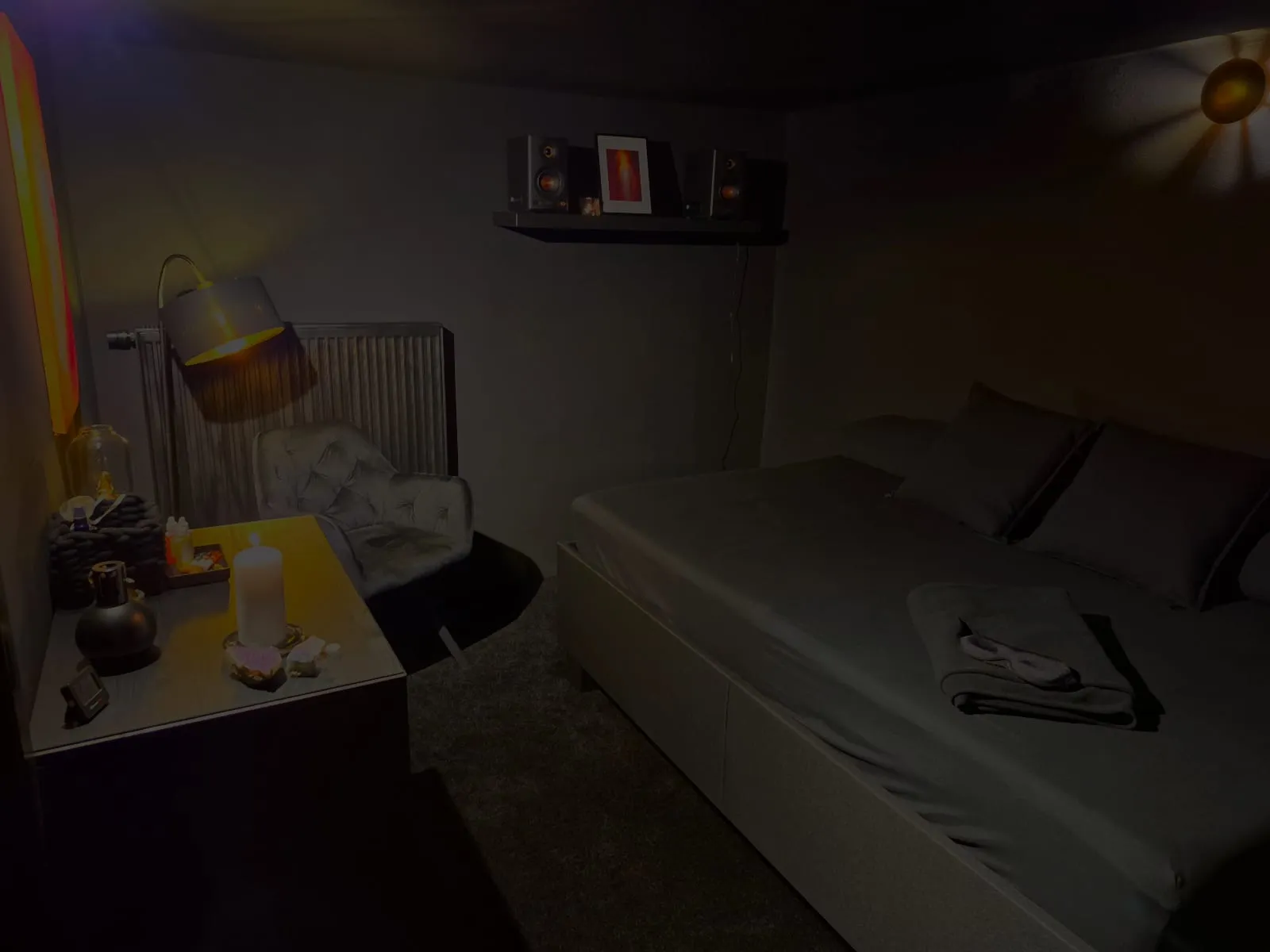 Der Schwarzraum im Dunkelsehen: eine Liege mit Decke und Augenmaske, ein Sessel, eine einzelne Lampe